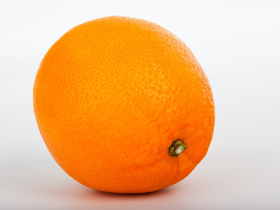 A ripe orange photographed against a plain background