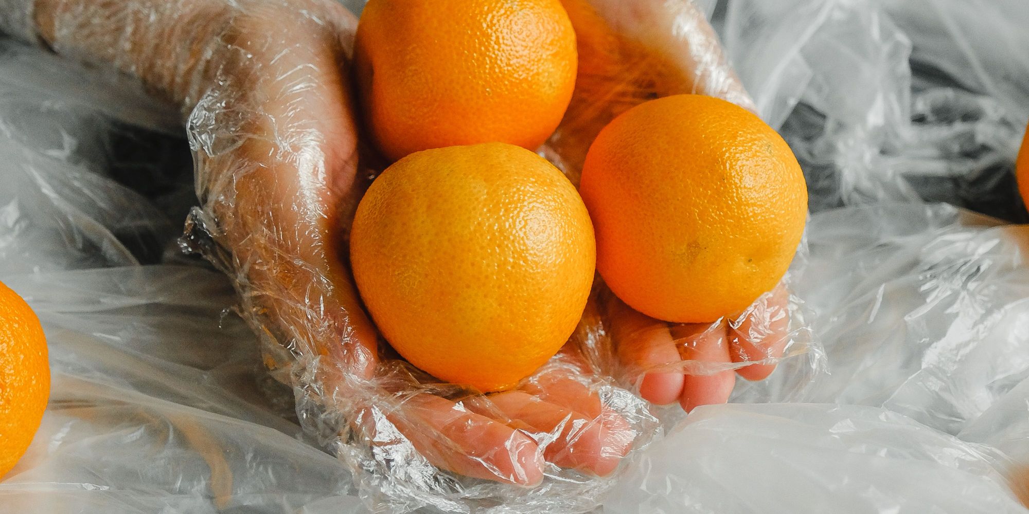 Gloved hands holding graded oranges during packing