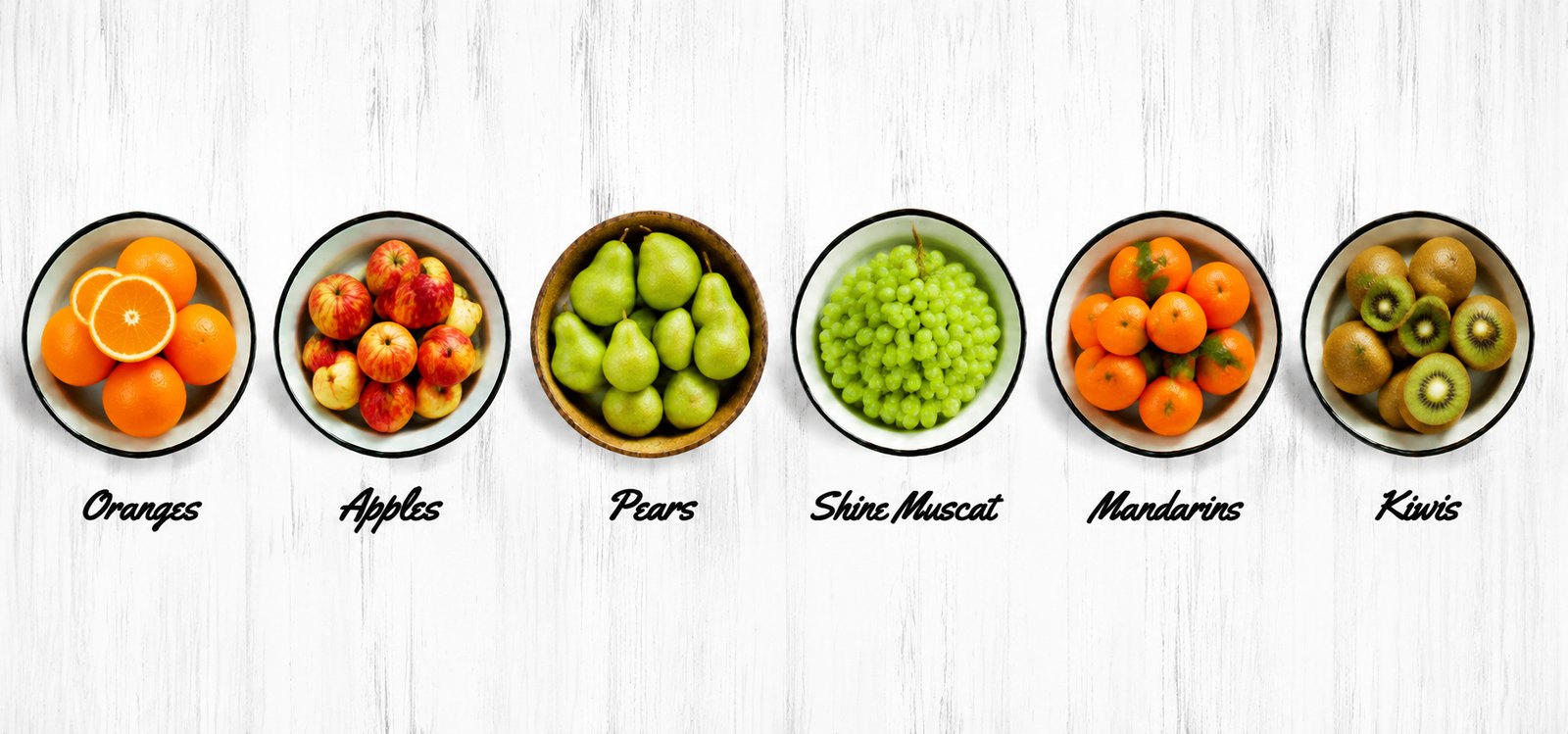 Bowls of oranges, apples, pears, Shine Muscat, mandarins and kiwifruit side by side